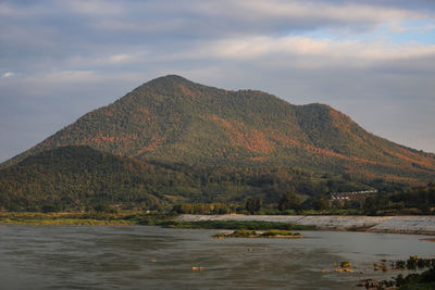 Scenic view of sea by mountains against sky