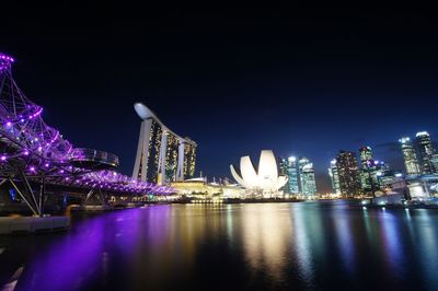 Illuminated marina bay sands with city against clear sky at night