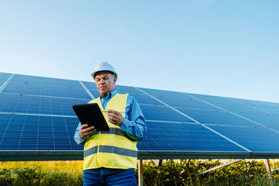 Engineer using tablet pc against solar panels