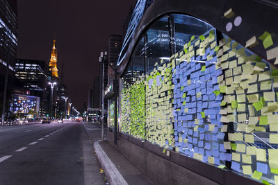 Adhesive notes on glass window by street at night