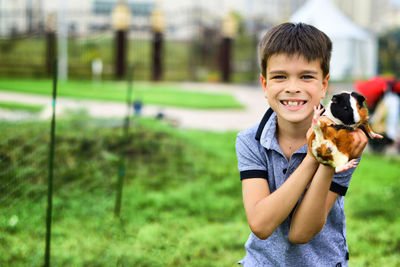 Portrait of smiling boy holding guinea pig