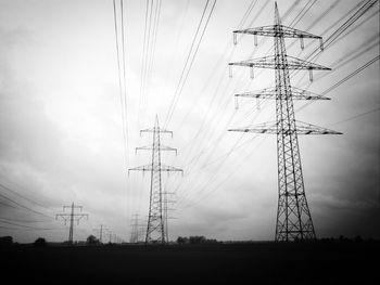 Low angle view of electricity pylon against sky