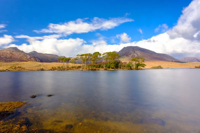 Scenic view of lake by mountains against sky