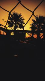 Silhouette palm trees against sky during sunset