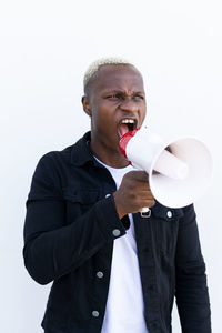 Young man standing against white background