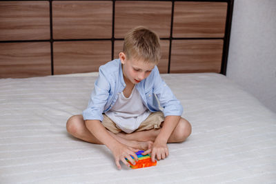 Boy playing with toy on bed