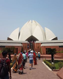 Rear view of people outside temple against clear sky