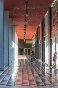 Rear view of people walking on corridor of building