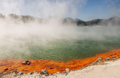 Scenic view of steam over hot spring