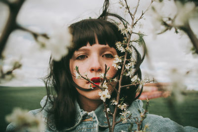 Portrait of young woman against plants