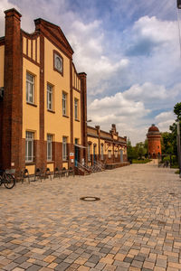 Houses by street in town against sky