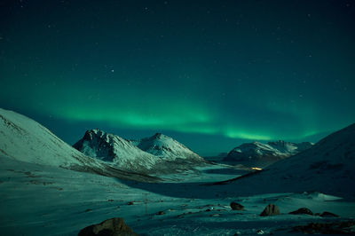 Scenic view of snowcapped mountains against sky at night