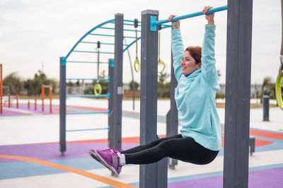 Rear view of young woman exercising in gym