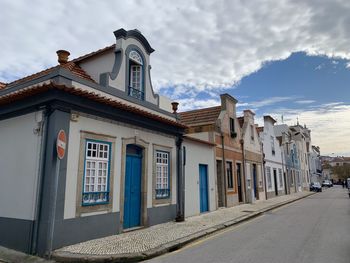 Buildings by street in town against sky