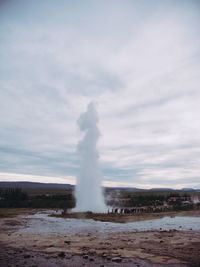 Geyser erupting against sky