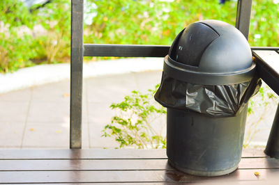 Close-up of garbage can on footpath