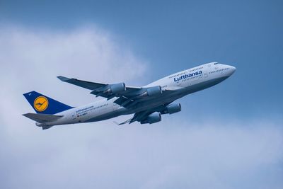 Low angle view of airplane flying against sky