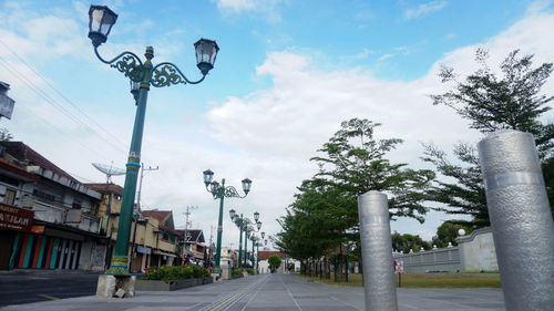 Street amidst road and buildings against sky