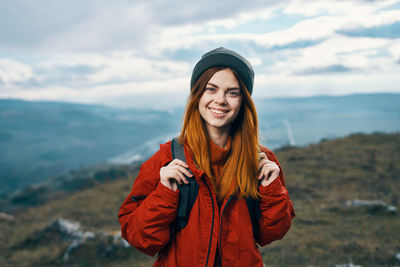 Portrait of smiling young woman standing in snow