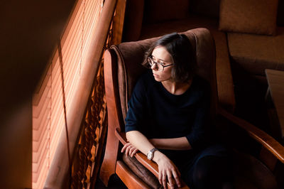 Young woman sitting on sofa at home