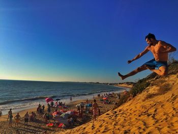 Man on beach against clear blue sky