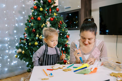 Portrait of girl drawing on christmas tree