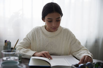 Girl doing homework at dining table