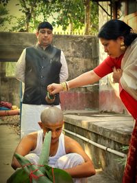 Full length of friends sitting outdoors