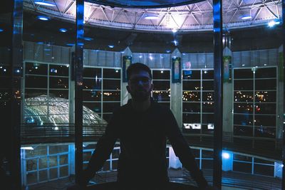 Full length portrait of young man standing at night