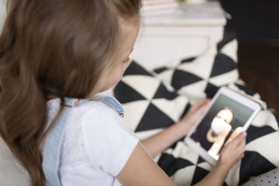 Girl using mobile phone on sofa at home