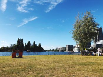 Scenic view of river by buildings against blue sky