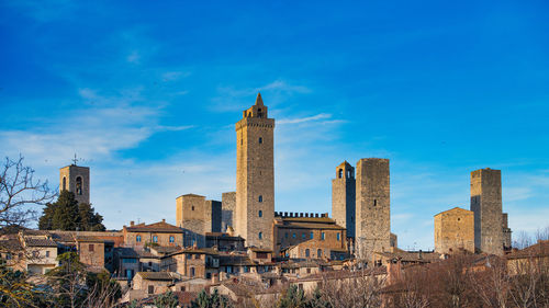 Buildings in city against blue sky