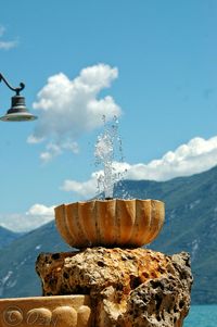 Rocks on beach against cloudy sky