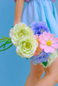 Plastik flowers aesthetic girl on blue background. minimal aqua 