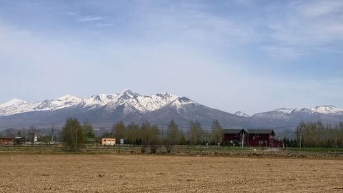 Scenic view of field and mountains against sky