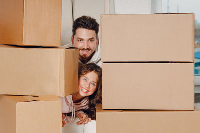 Portrait of young woman holding cardboard box