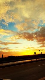 Silhouette road against sky during sunset