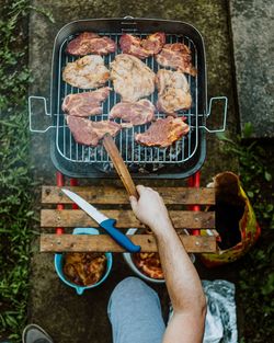 High angle view of man preparing food on barbecue grill