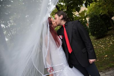 Tilt shot of young wedding couple kissing at back yard