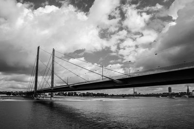 Low angle view of suspension bridge over river against sky