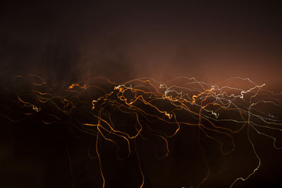 Close-up of illuminated lighting equipment against black background