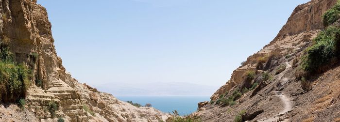 Scenic view of sea and mountains against clear sky