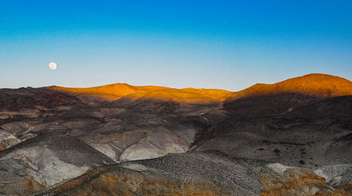 Scenic view of mountains against clear blue sky