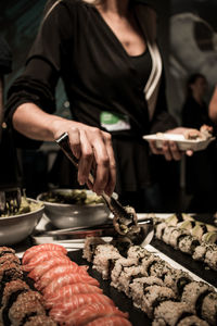 Midsection of woman taking food