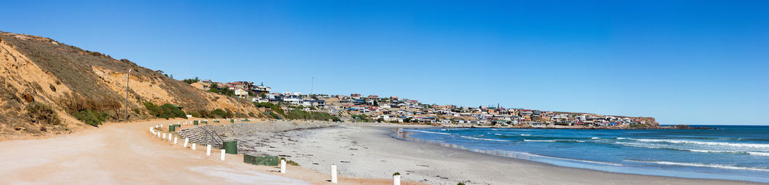 Panoramic view of beach against clear blue sky