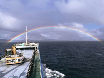 Scenic view of rainbow over sea against sky