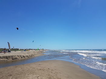 Scenic view of beach against clear blue sky