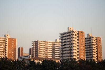 Buildings in city against clear sky
