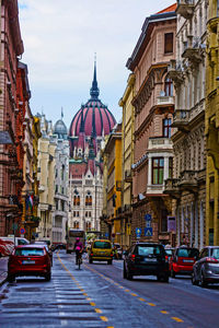 View of street amidst buildings against sky in city