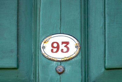 Close-up of information sign on wooden door